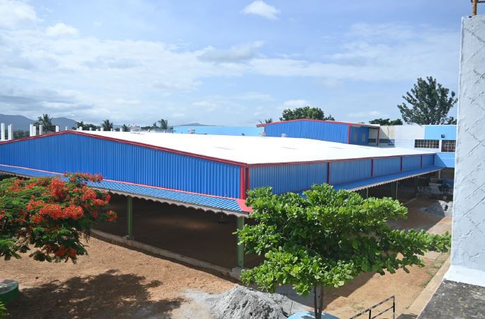 A new school with blue siding was built at a mission site in India. Nov 2024 PR - INDIA: Students benefit from new multipurpose hall thanks to donor funding from Salesian Missions